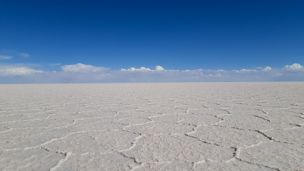 a vast expanse of white sand with a blue sky in the background