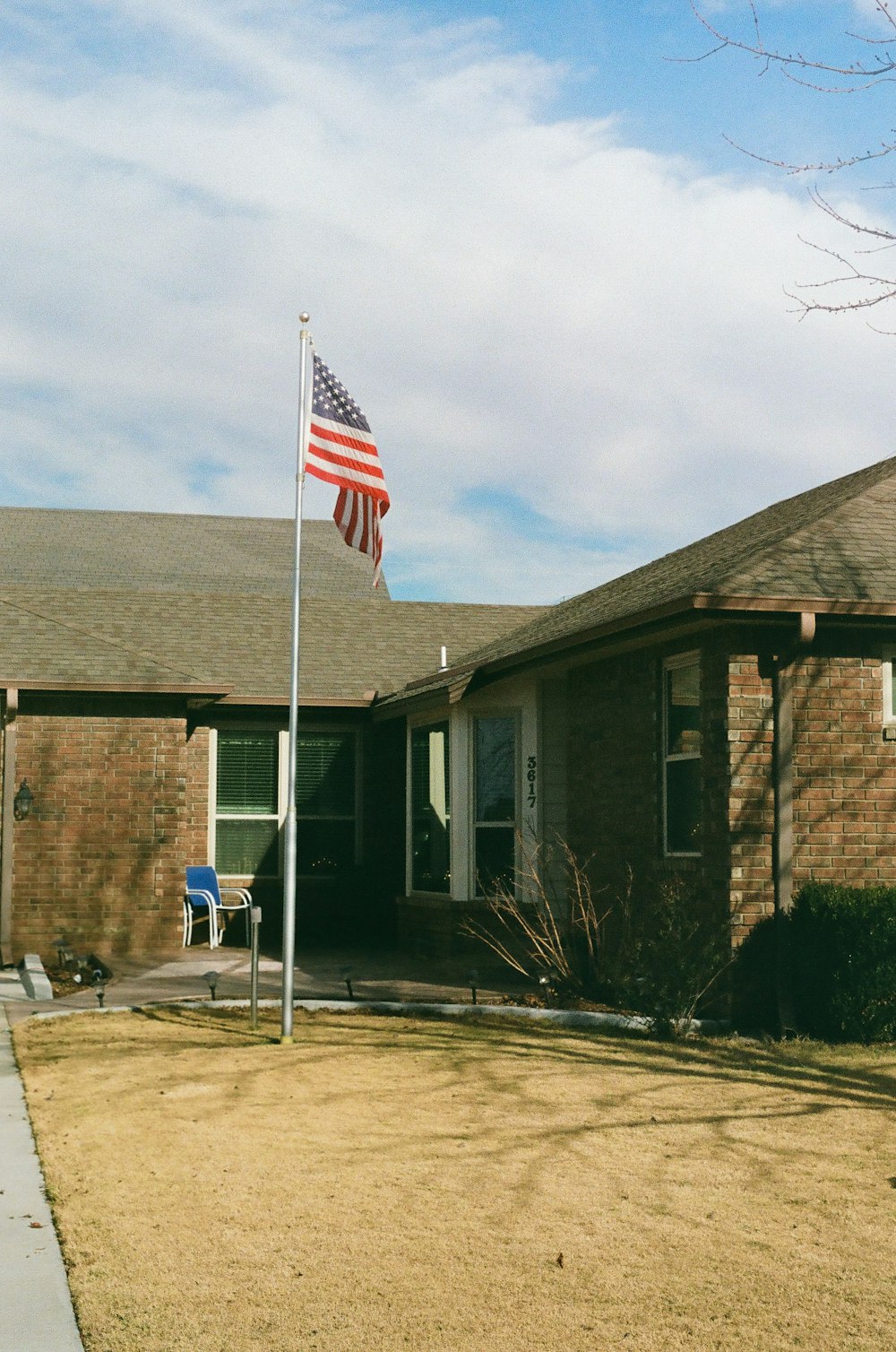 a small american flag on a pole in front of a house