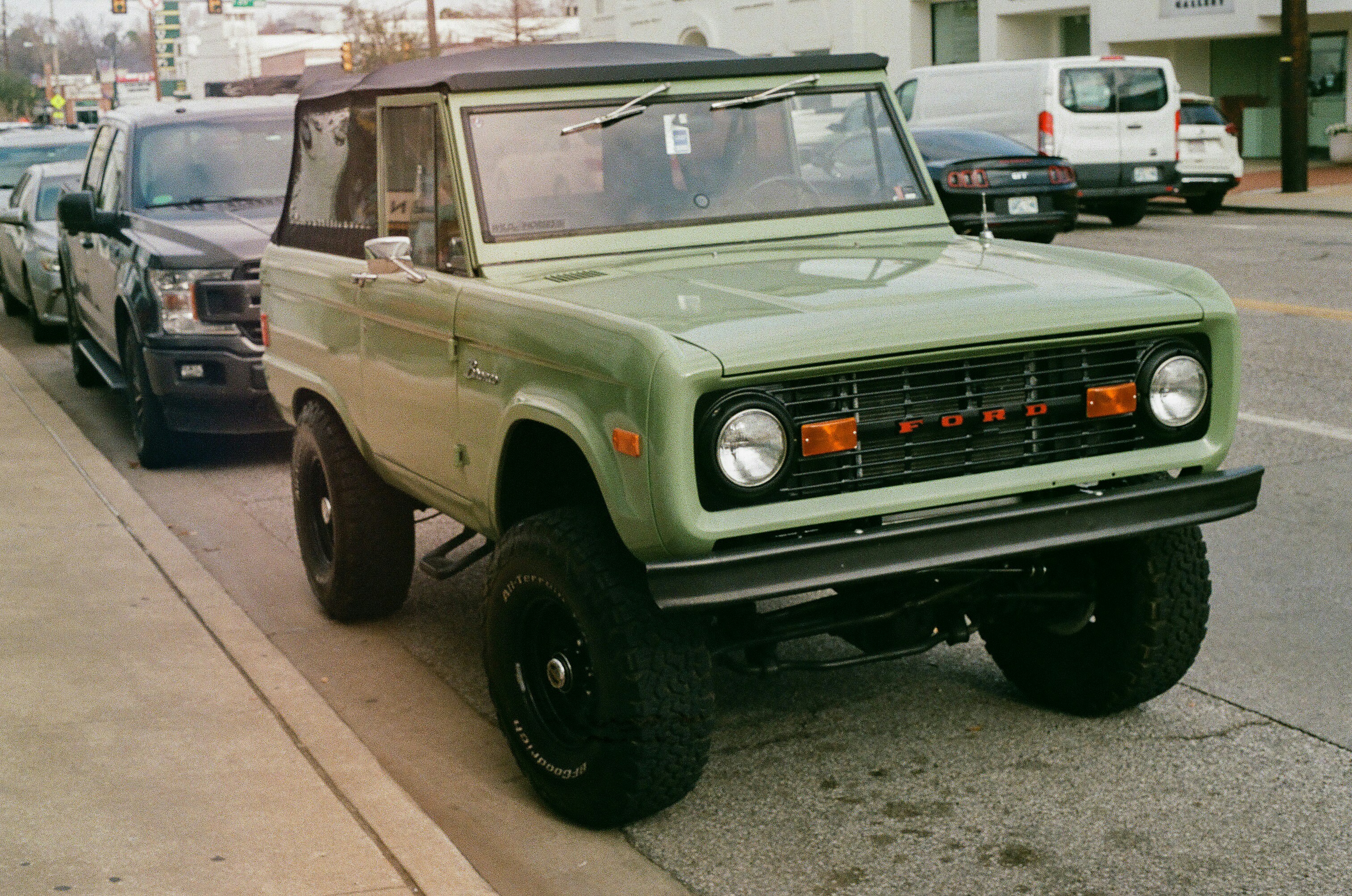 a green truck parked on the side of a road