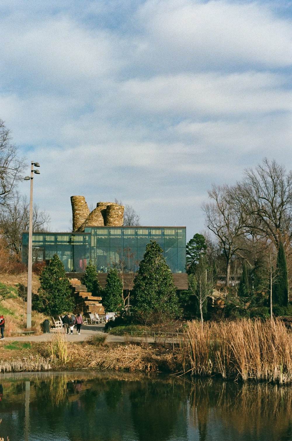 a large glass building sitting on top of a lush green hillside