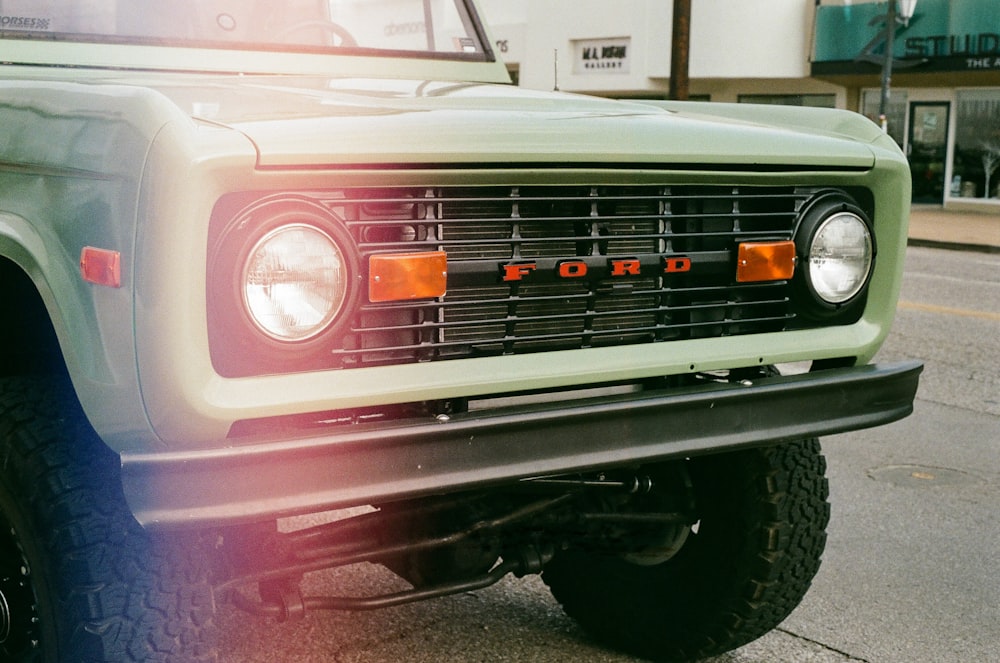 a close up of a green truck on a street