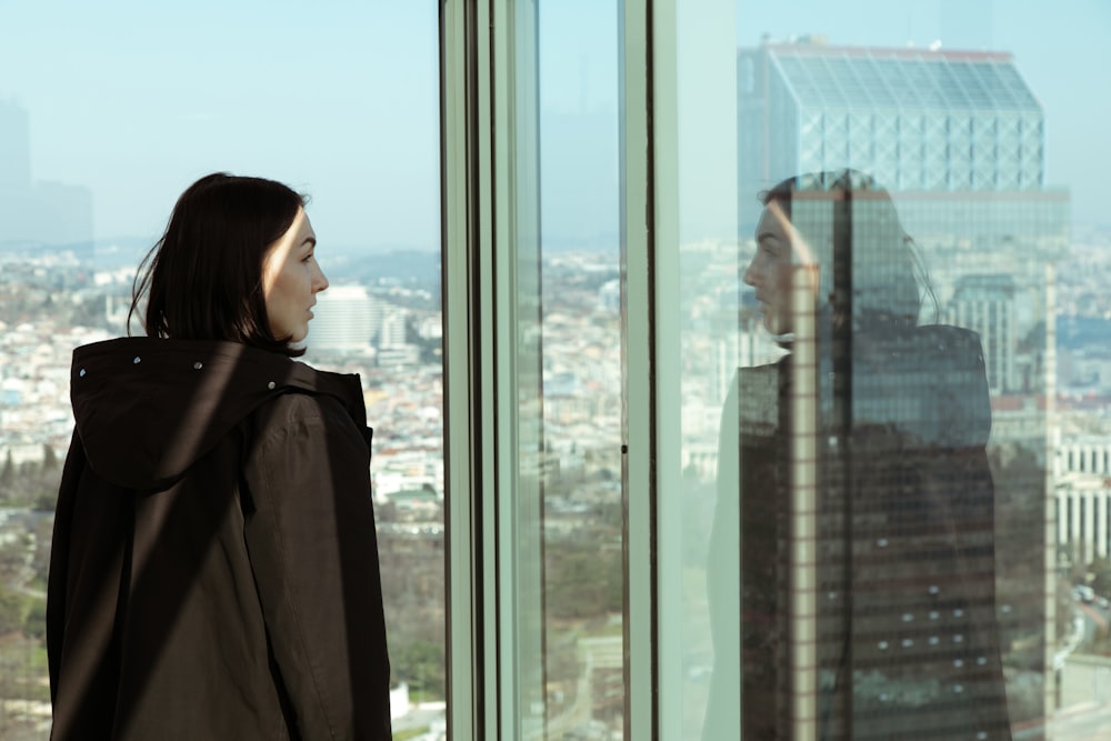 Una mujer mirando por la ventana a una ciudad