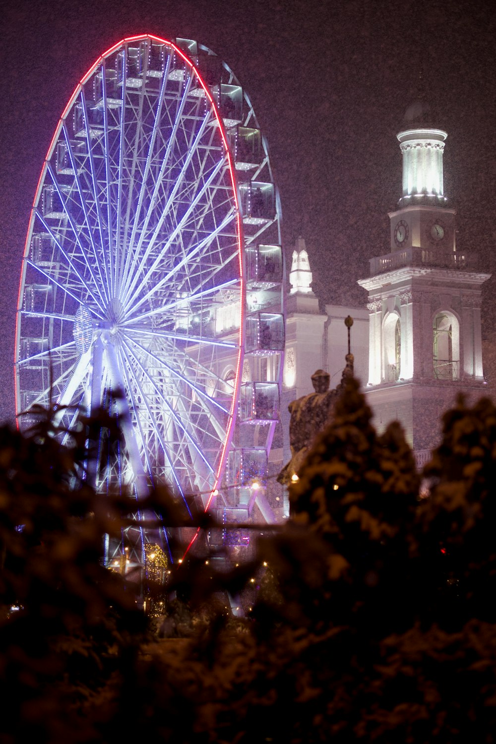 a large ferris wheel sitting next to a tall building