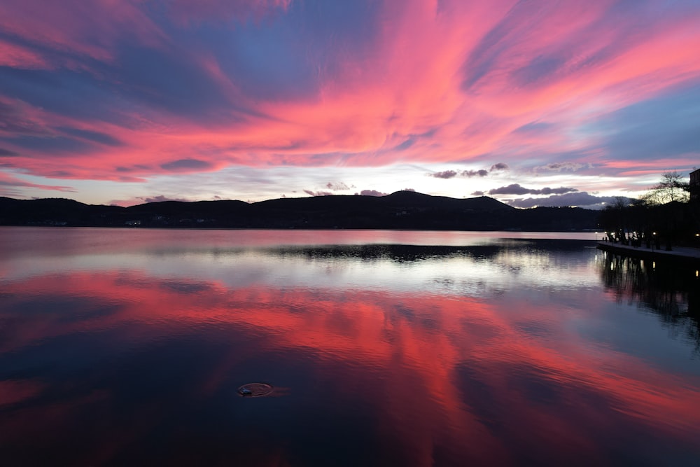 a pink and blue sky is reflected in the water