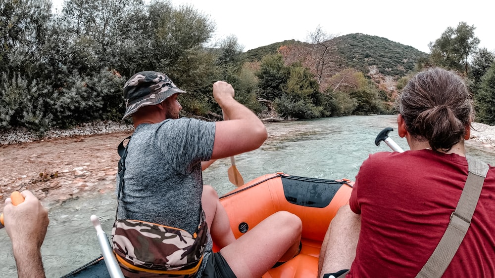 a couple of men riding on the back of an inflatable boat