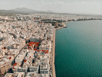 an aerial view of a city next to a body of water