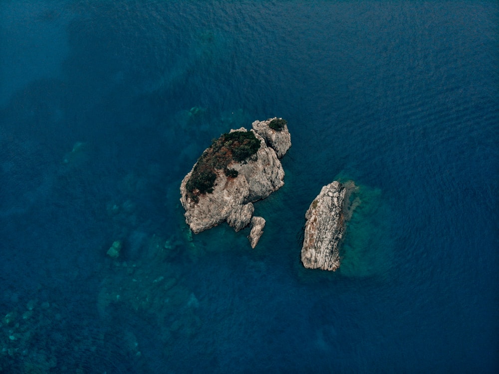 two large rocks in the middle of a body of water