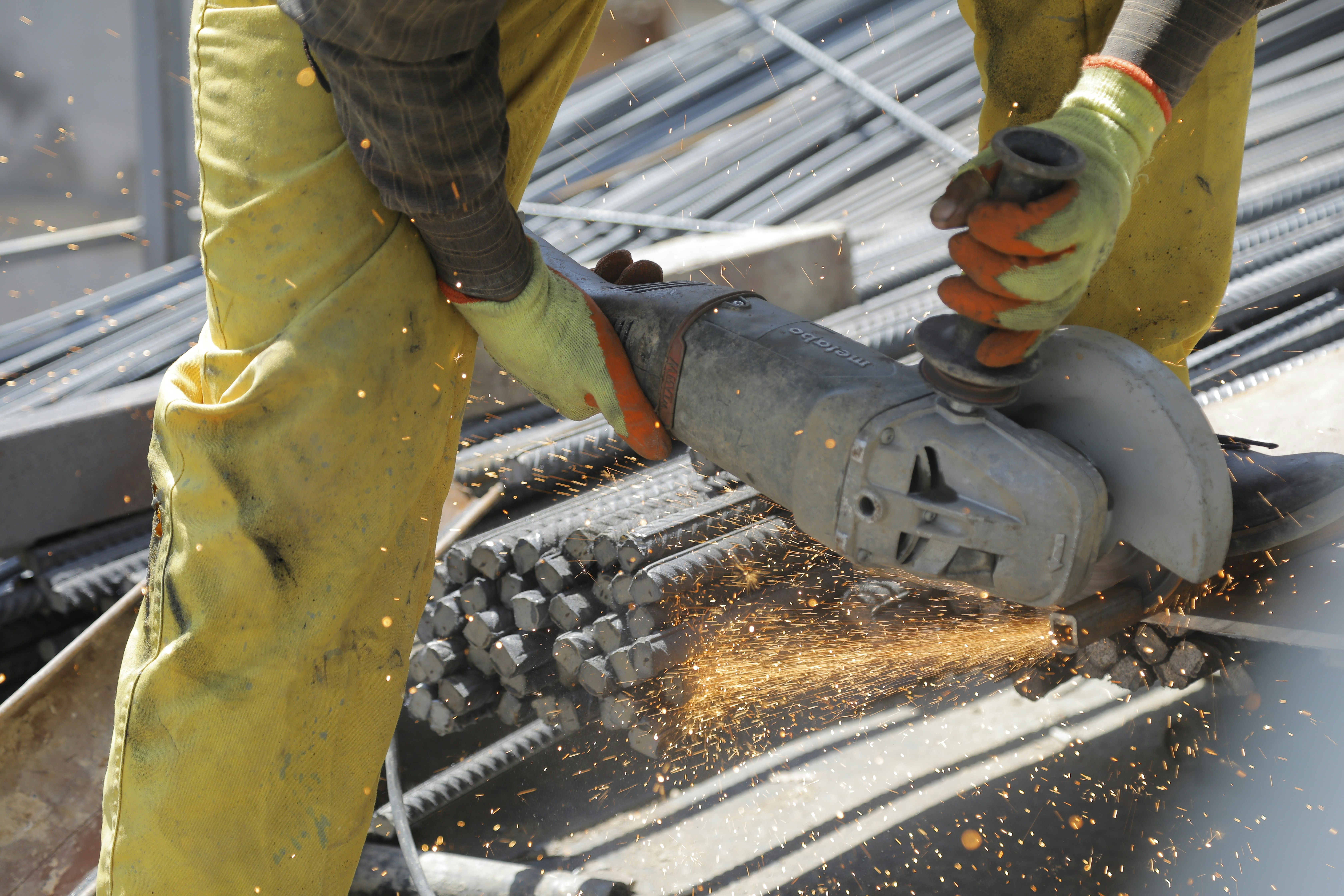 Ein Mann benutzt eine Schleifmaschine, um Metall zu schneiden