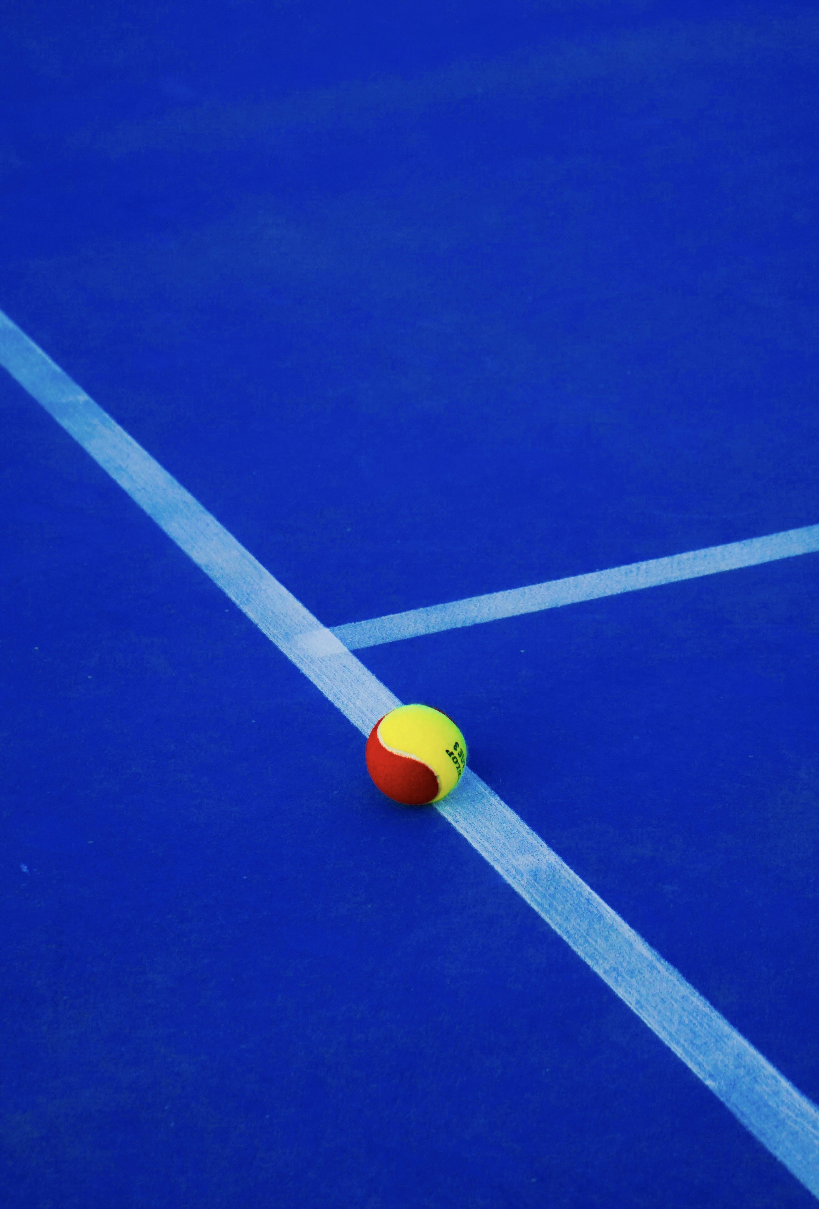 a tennis ball on a blue tennis court