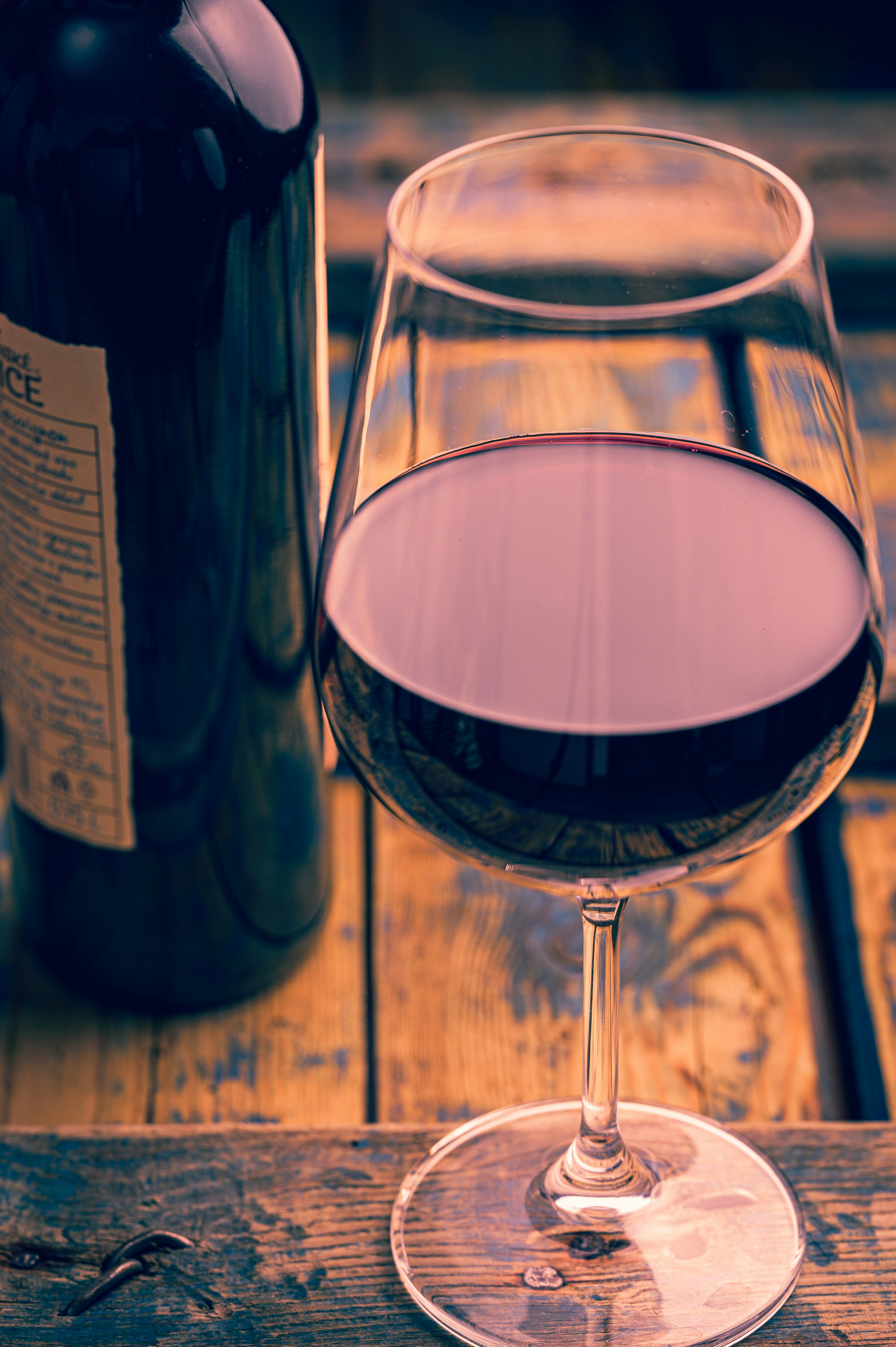 a glass of wine sitting next to a bottle of wine