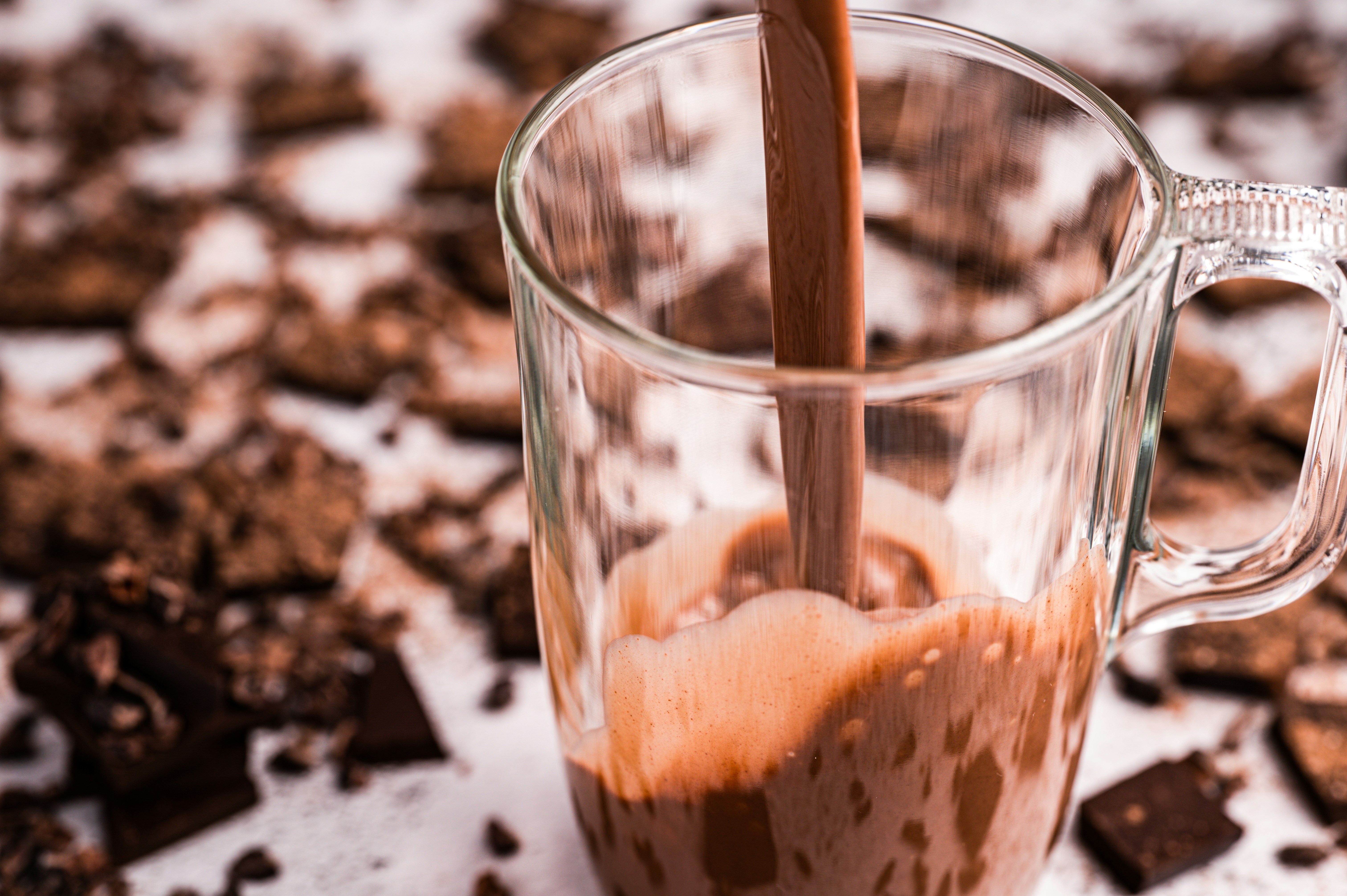 a glass mug filled with liquid and chocolate chips