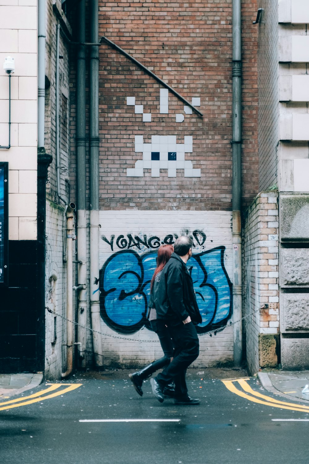 a couple of people walking down a street