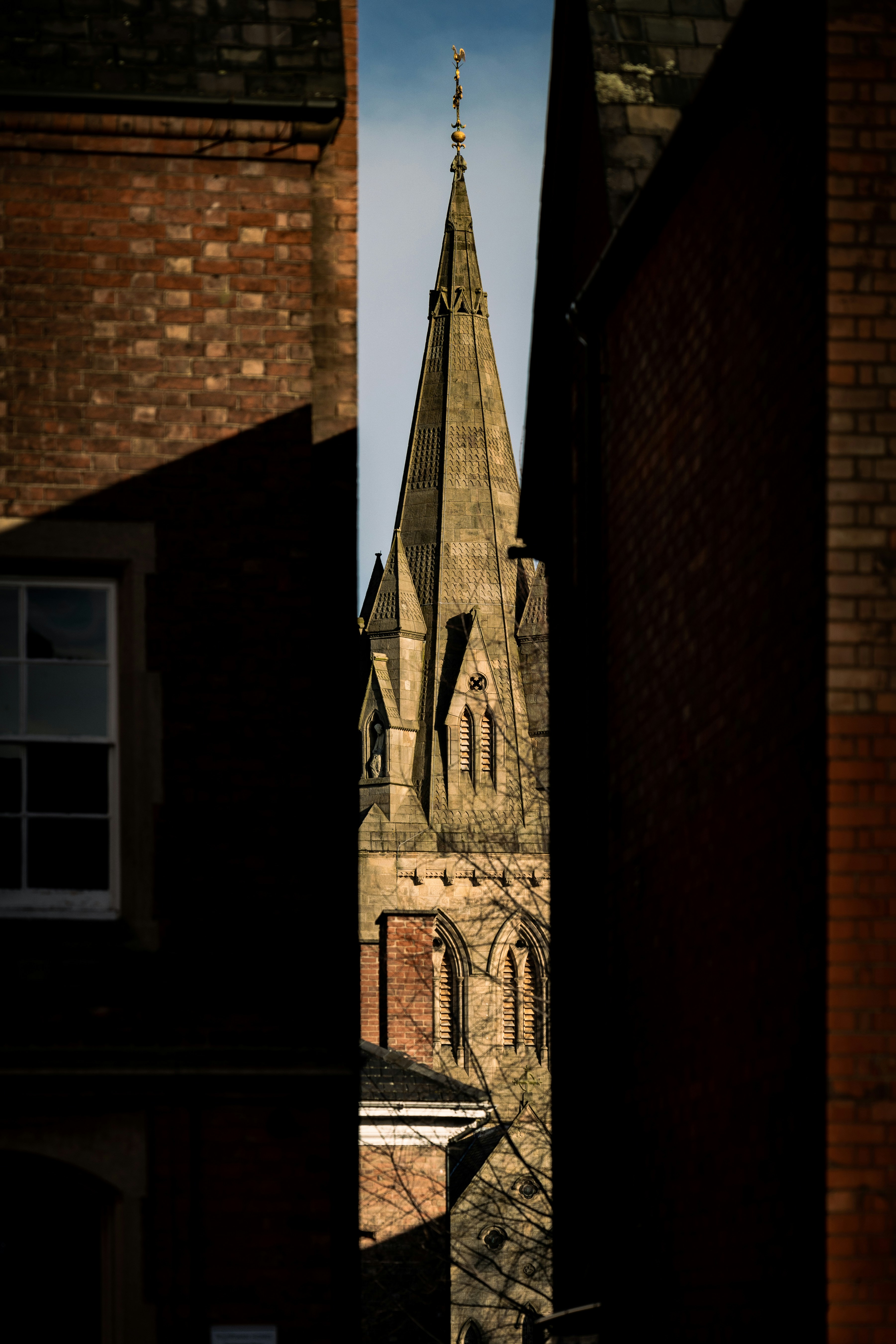 a church steeple seen through a narrow alley way
