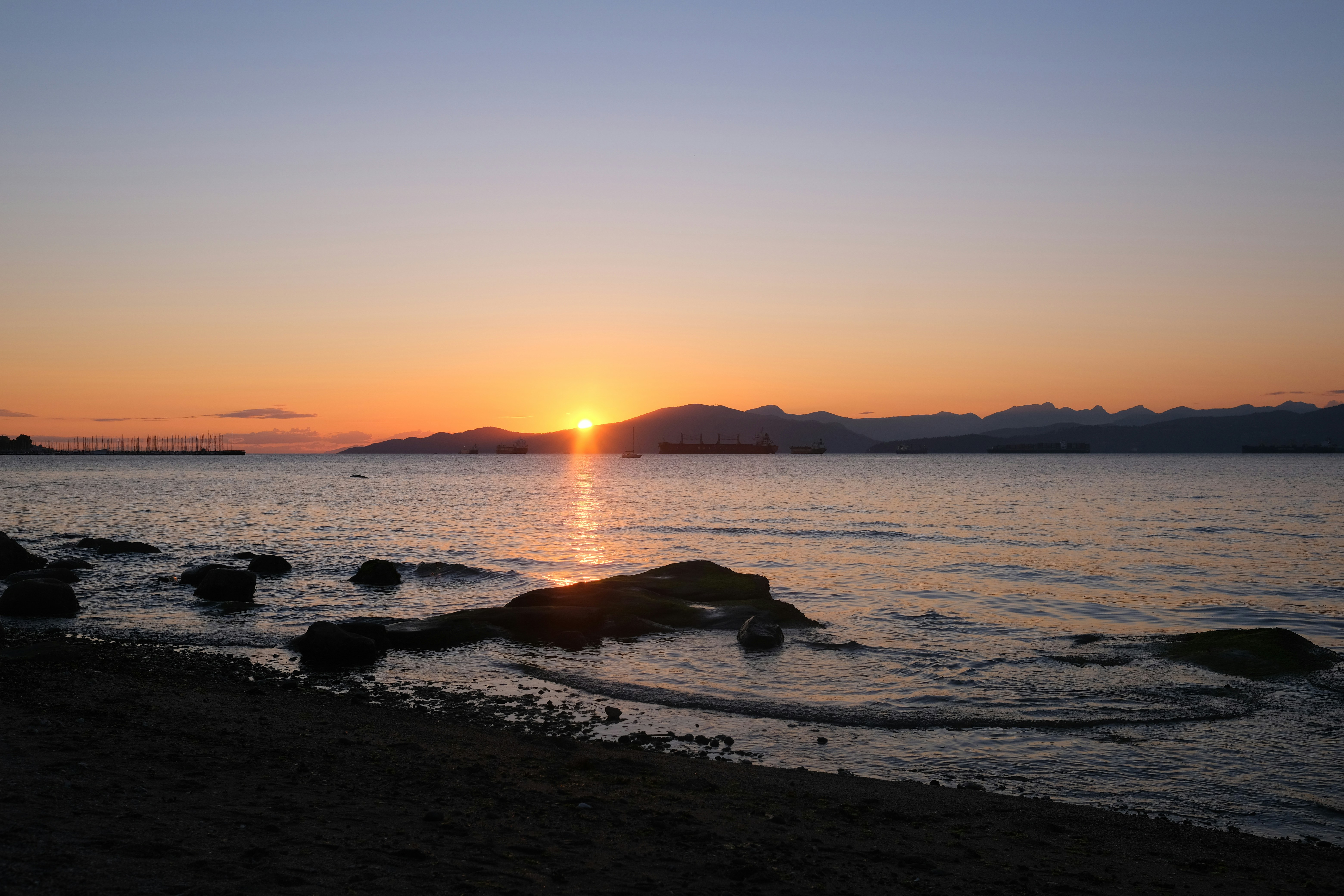 the sun is setting over a body of water