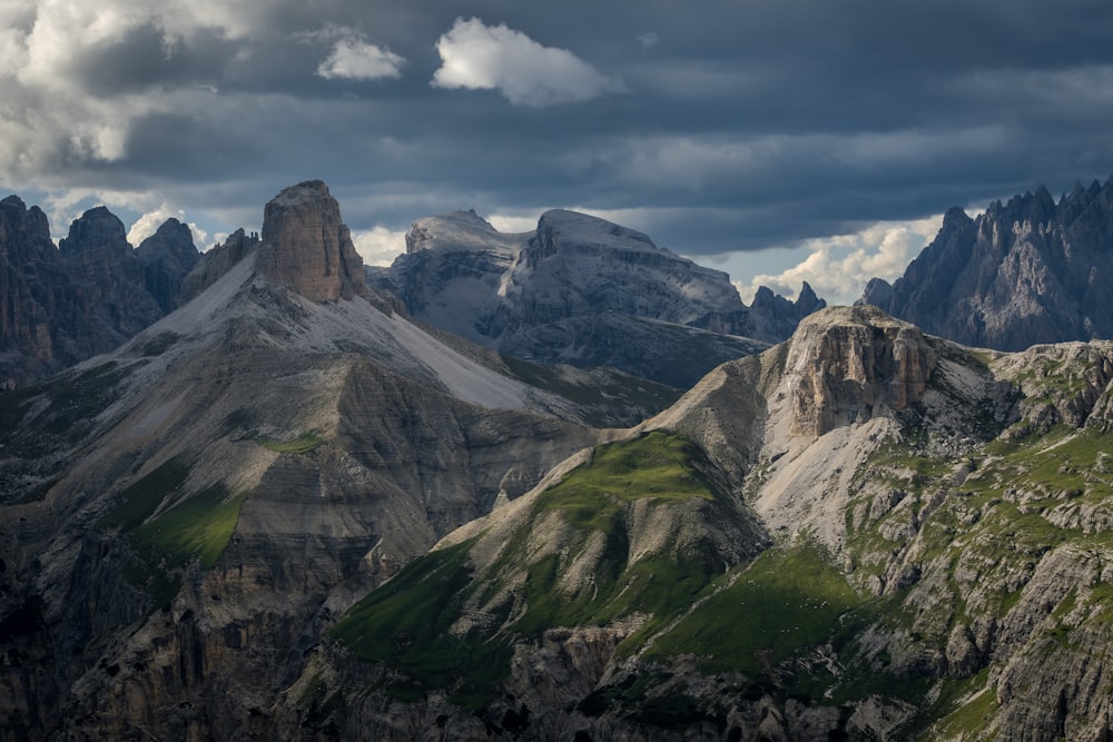 a group of mountains with a cloudy sky in the background