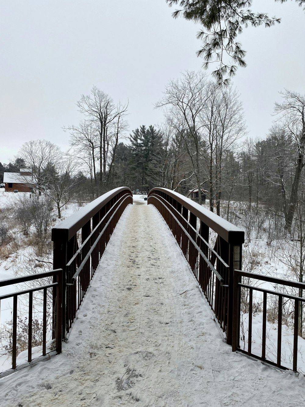a wooden bridge with snow on the ground