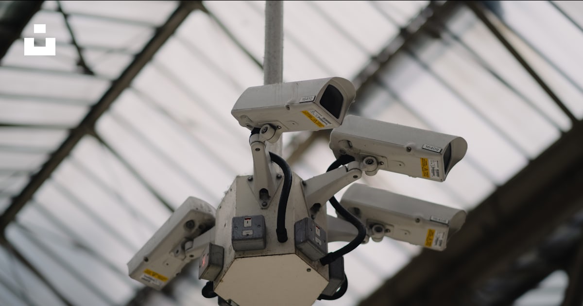 A bunch of surveillance cameras hanging from a ceiling photo – Free ...