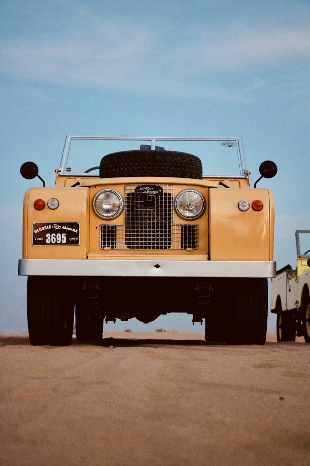 a yellow truck parked on top of a dirt field