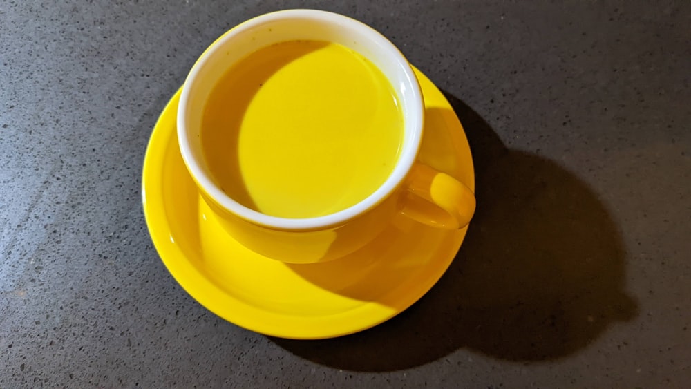 Una taza de té se sienta en un platillo amarillo