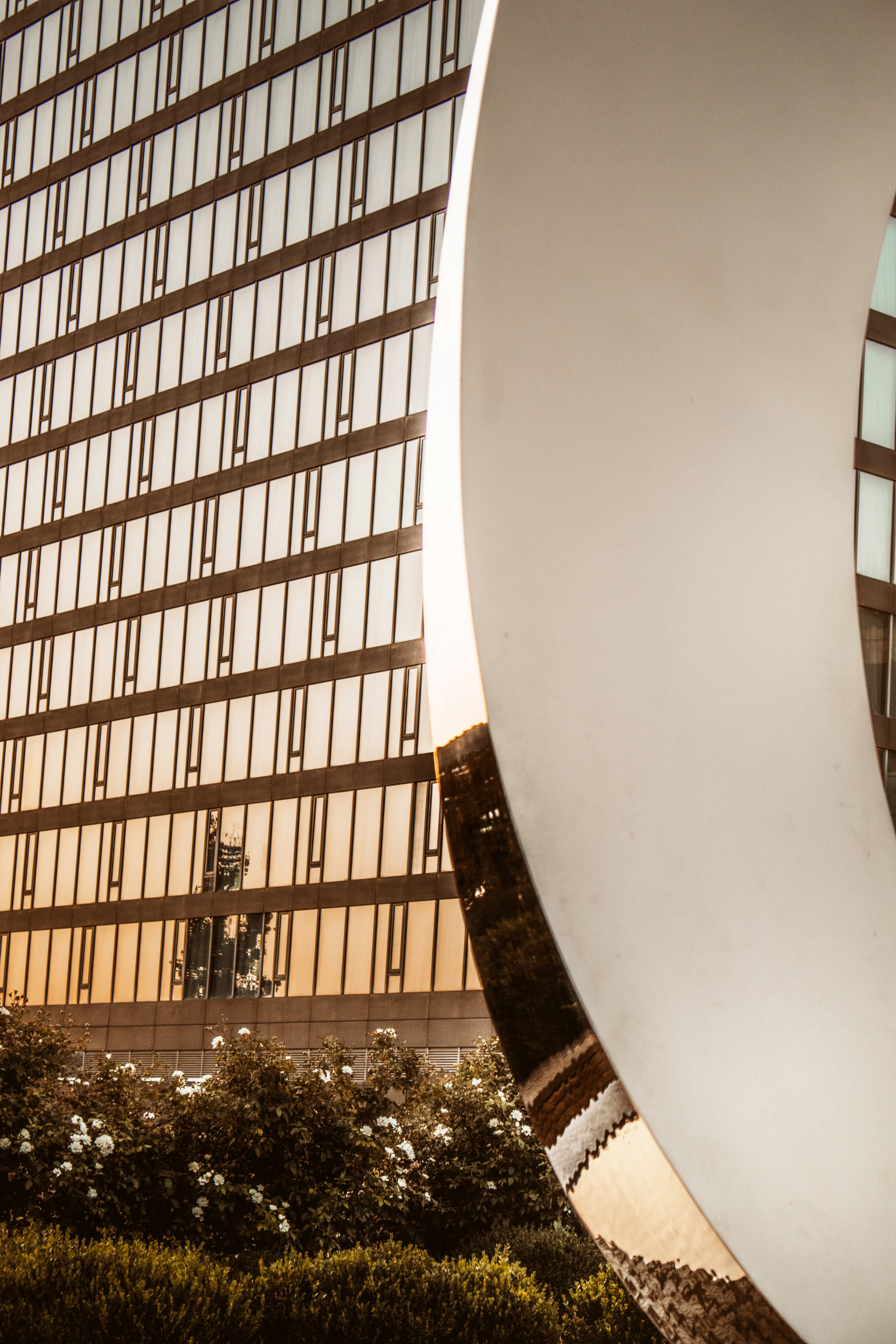 a tall building with a large circular sculpture in front of it