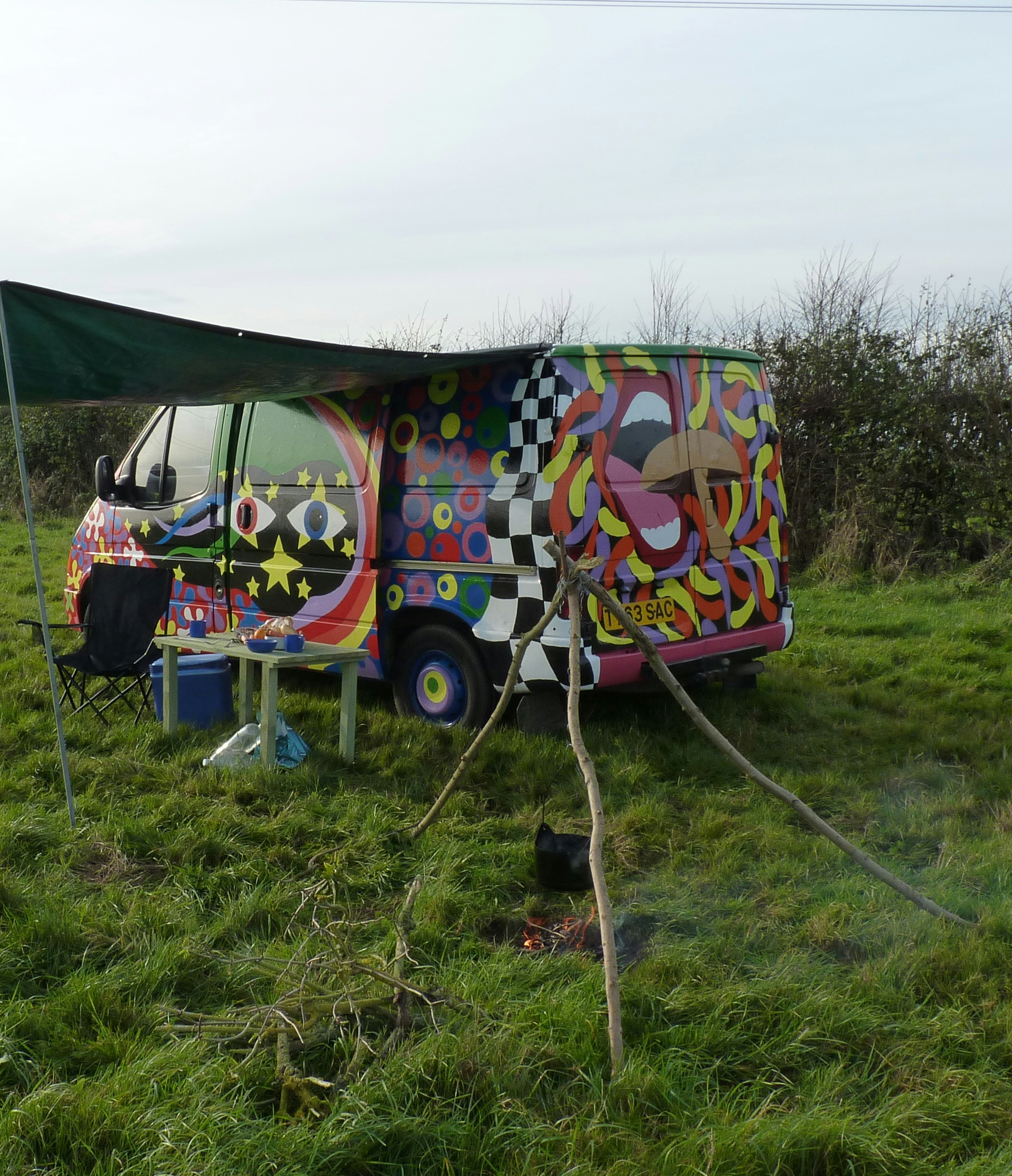 a colorful bus is parked in a grassy field