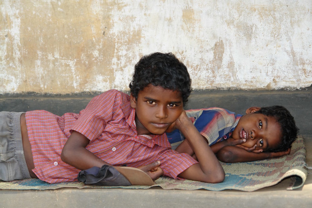 a couple of kids laying on top of a blanket