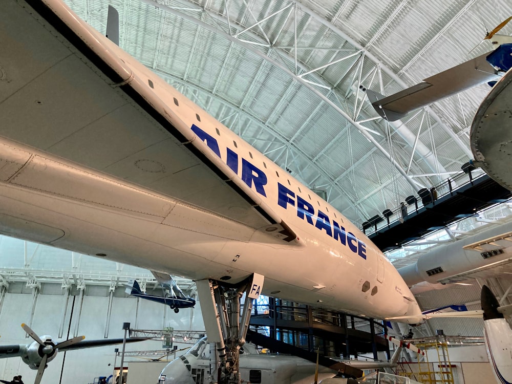 um grande avião branco sentado dentro de um hangar