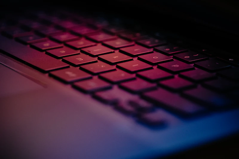 Laptop keyboard glowing in red and purple light