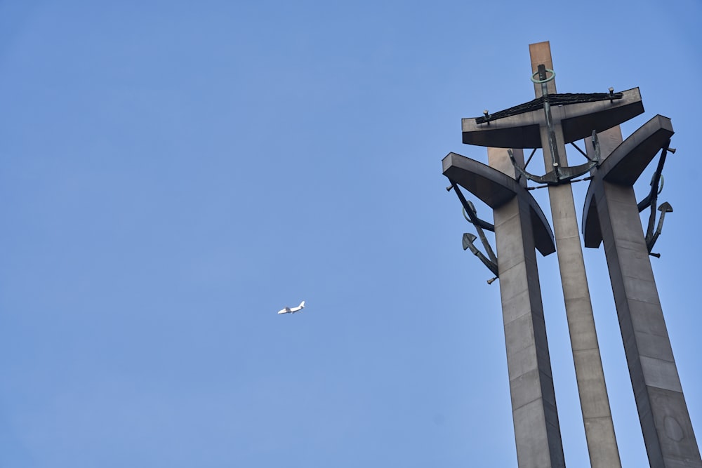 a plane flying in the sky next to a clock tower