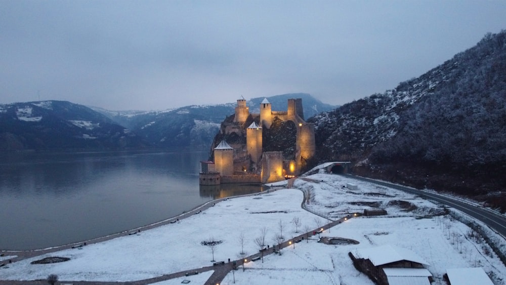 a castle is lit up on a snowy day
