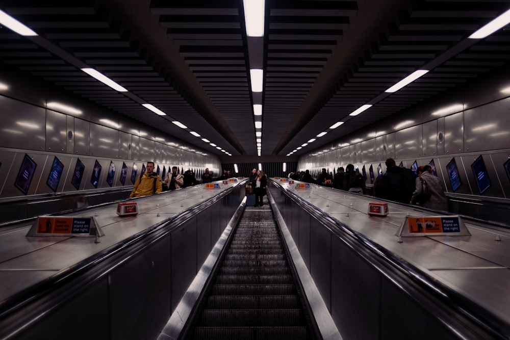 a group of people riding down an escalator