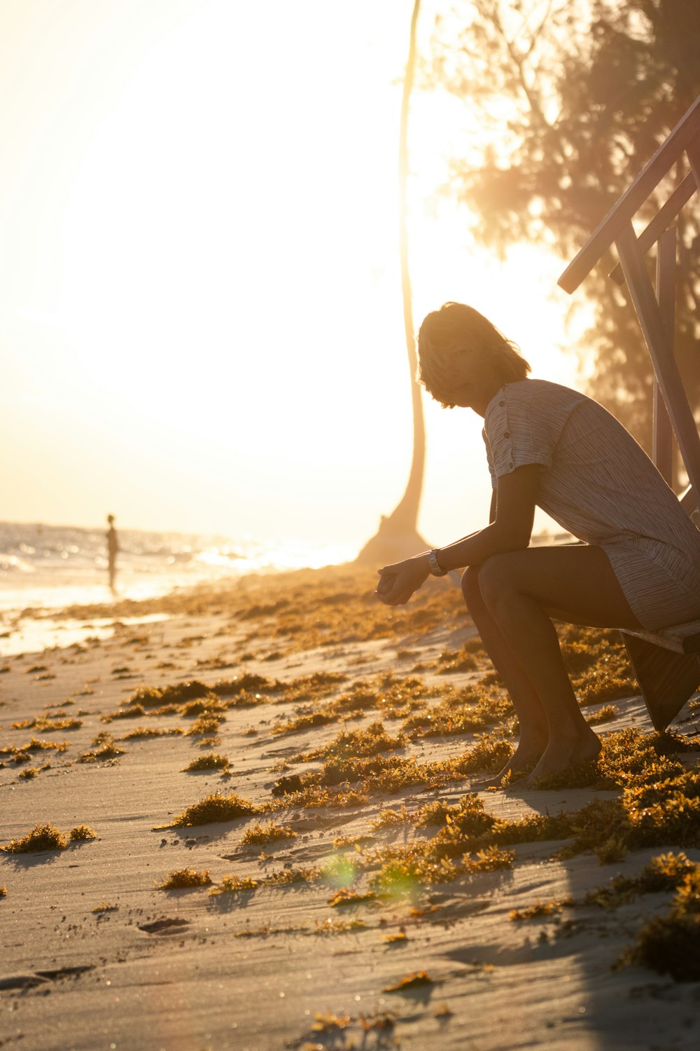 a person sitting on a bench on a beach