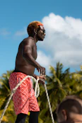 a man with no shirt on is holding a rope