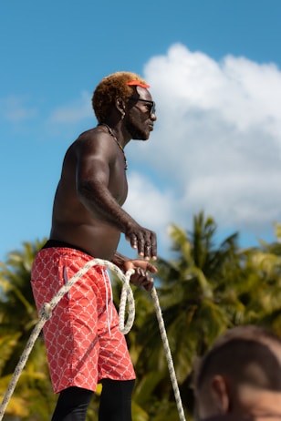 a man with no shirt on is holding a rope