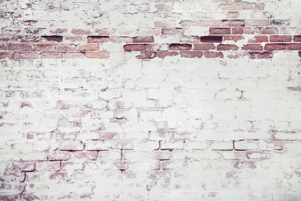 a white brick wall with a red stop sign on it