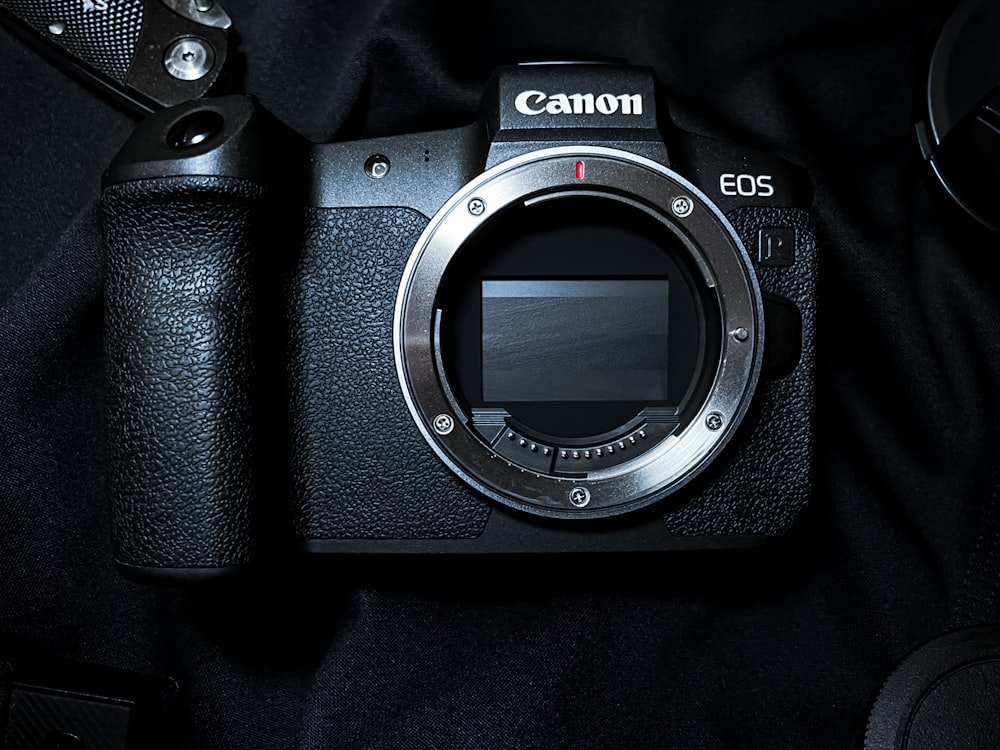 Eine Canon EOS Kamera sitzt auf einem schwarzen Tuch
