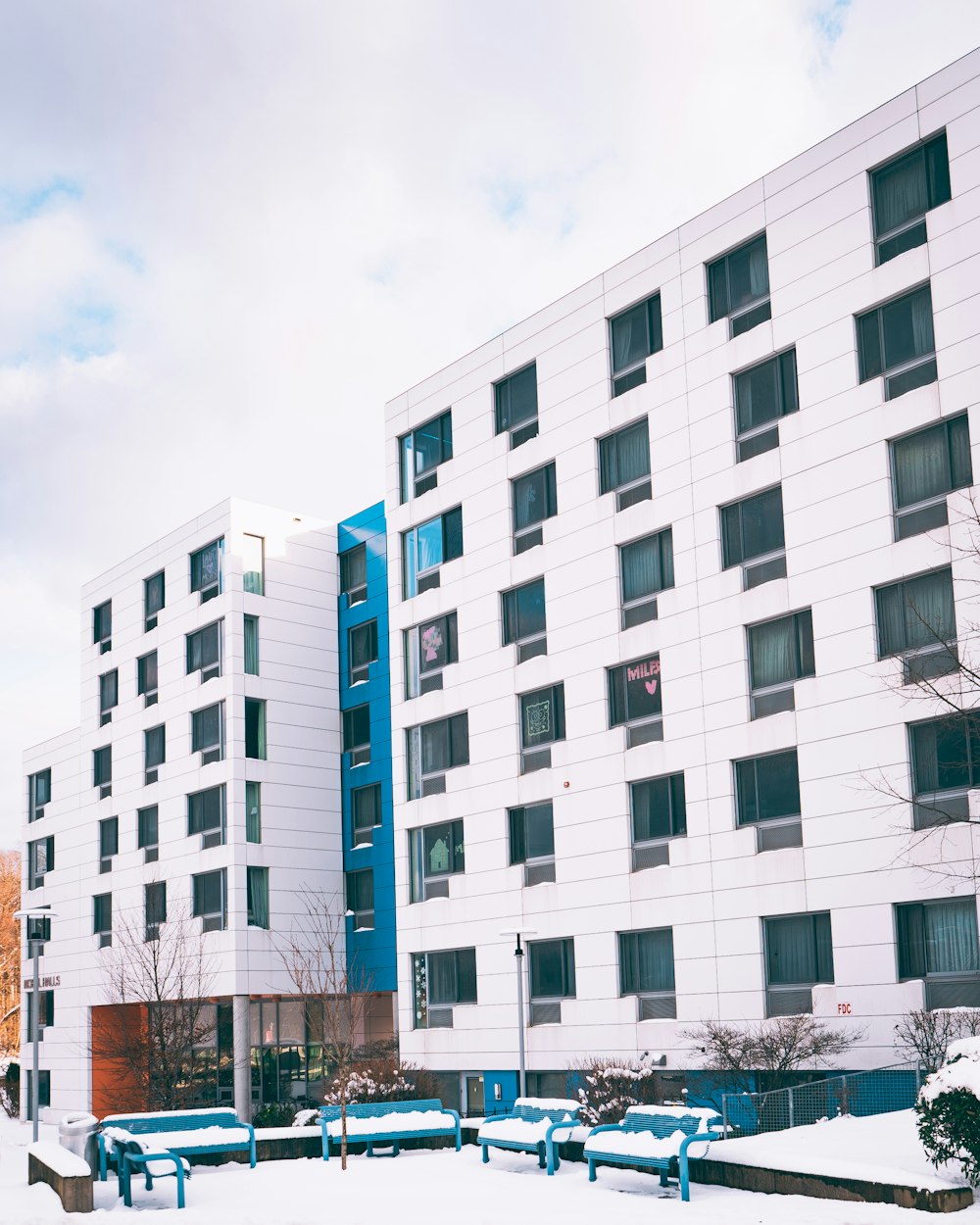 a large white building with a blue bench in front of it