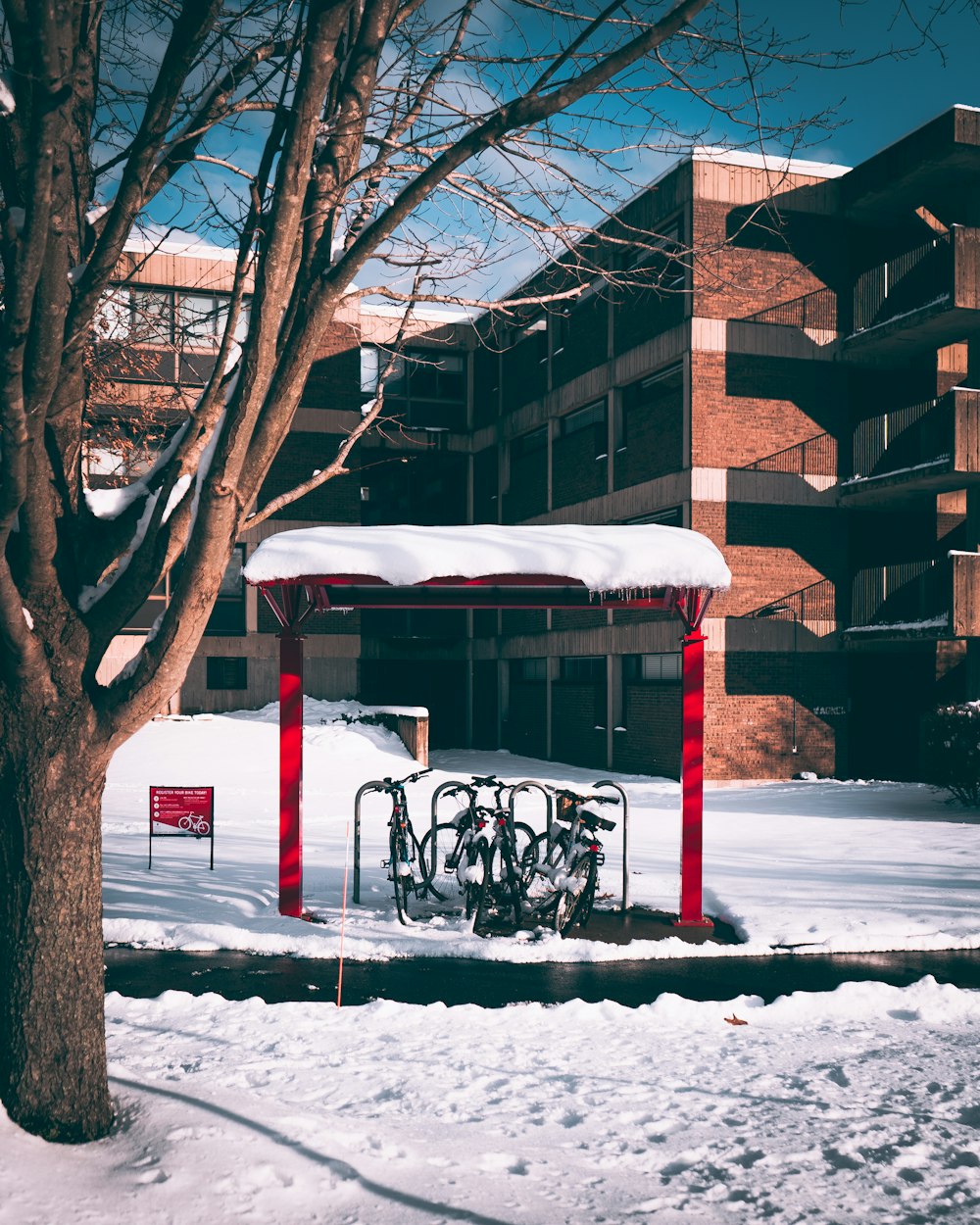 a bike rack is covered with snow in front of a building