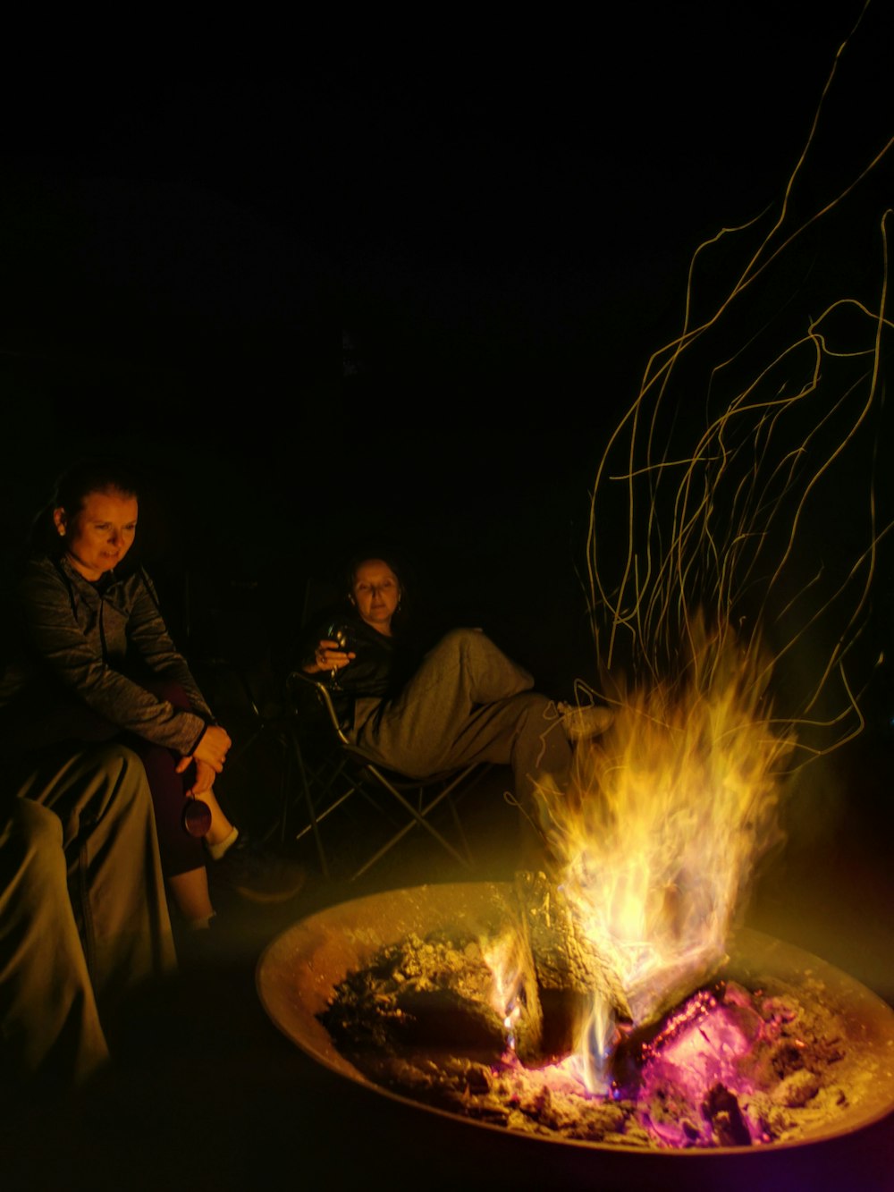 a group of people sitting around a fire pit