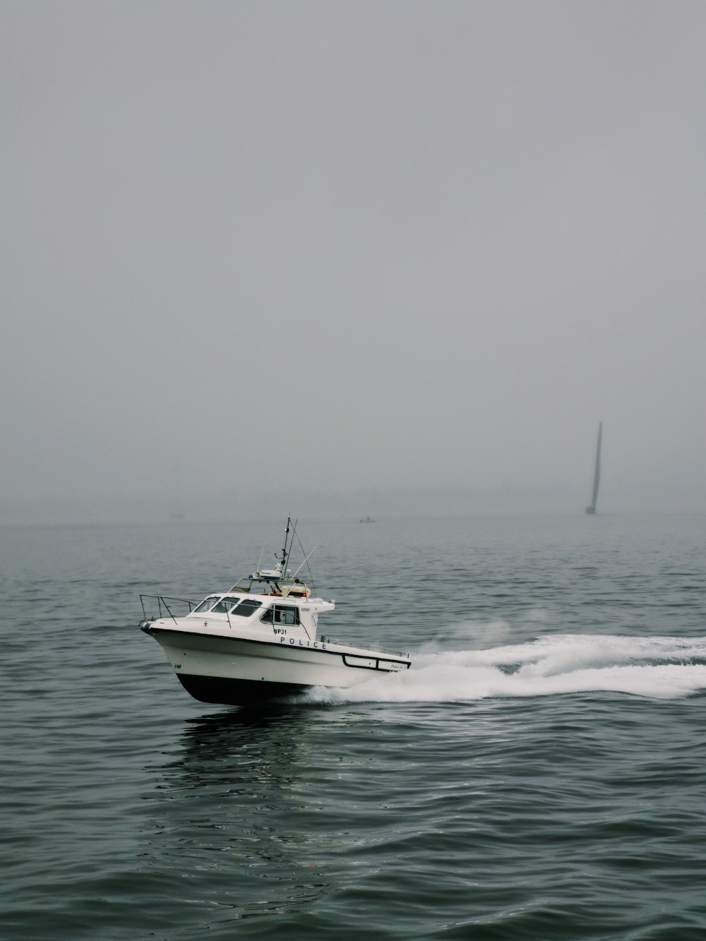 a white boat traveling across a large body of water