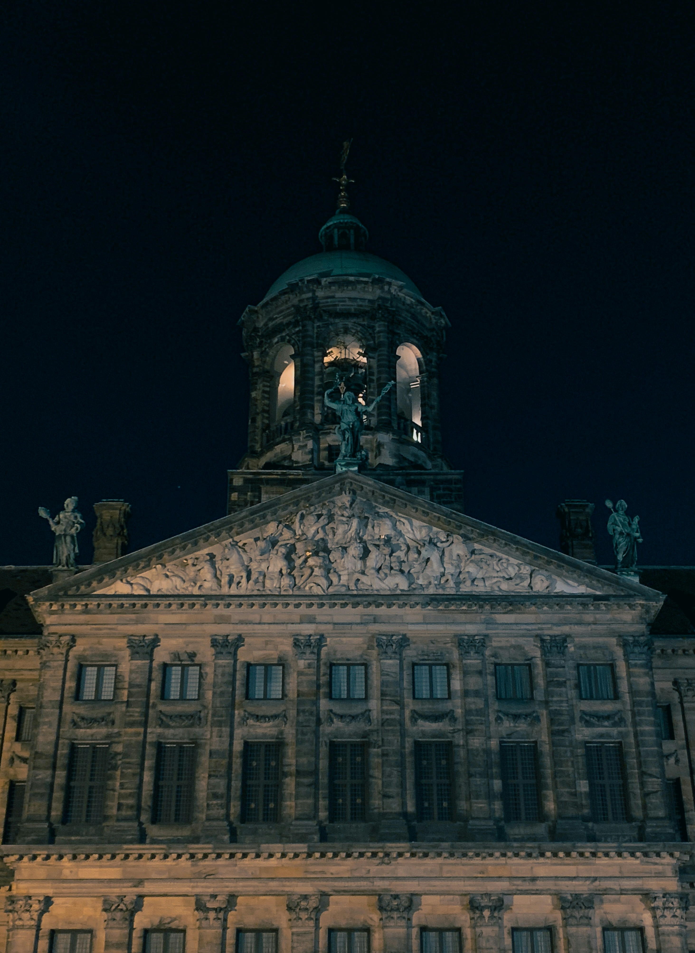 Un gran edificio con una torre del reloj por la noche