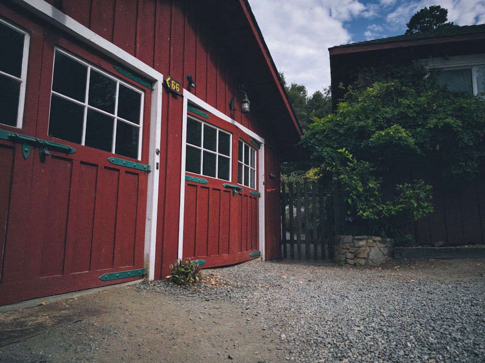 a red barn with a white door and windows