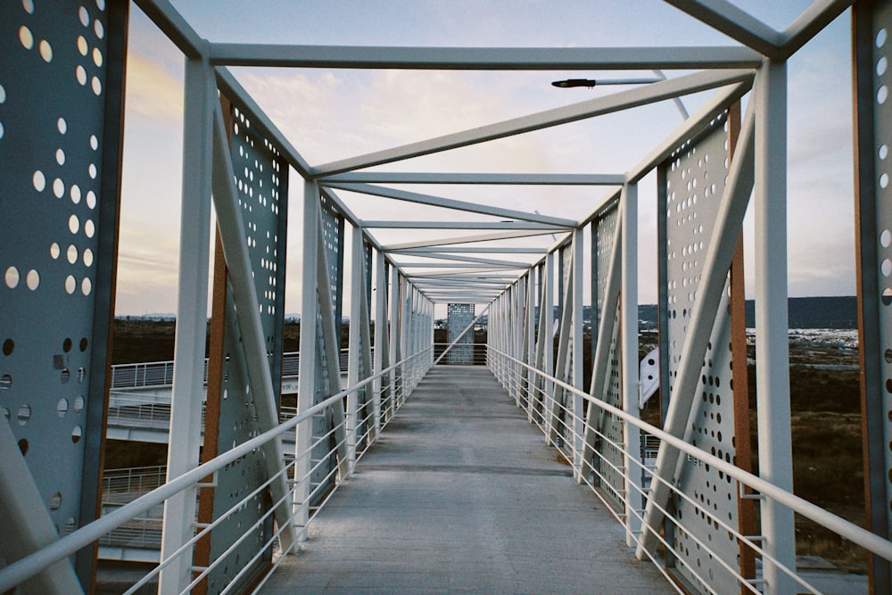 a walkway with metal railings and a clock tower in the background