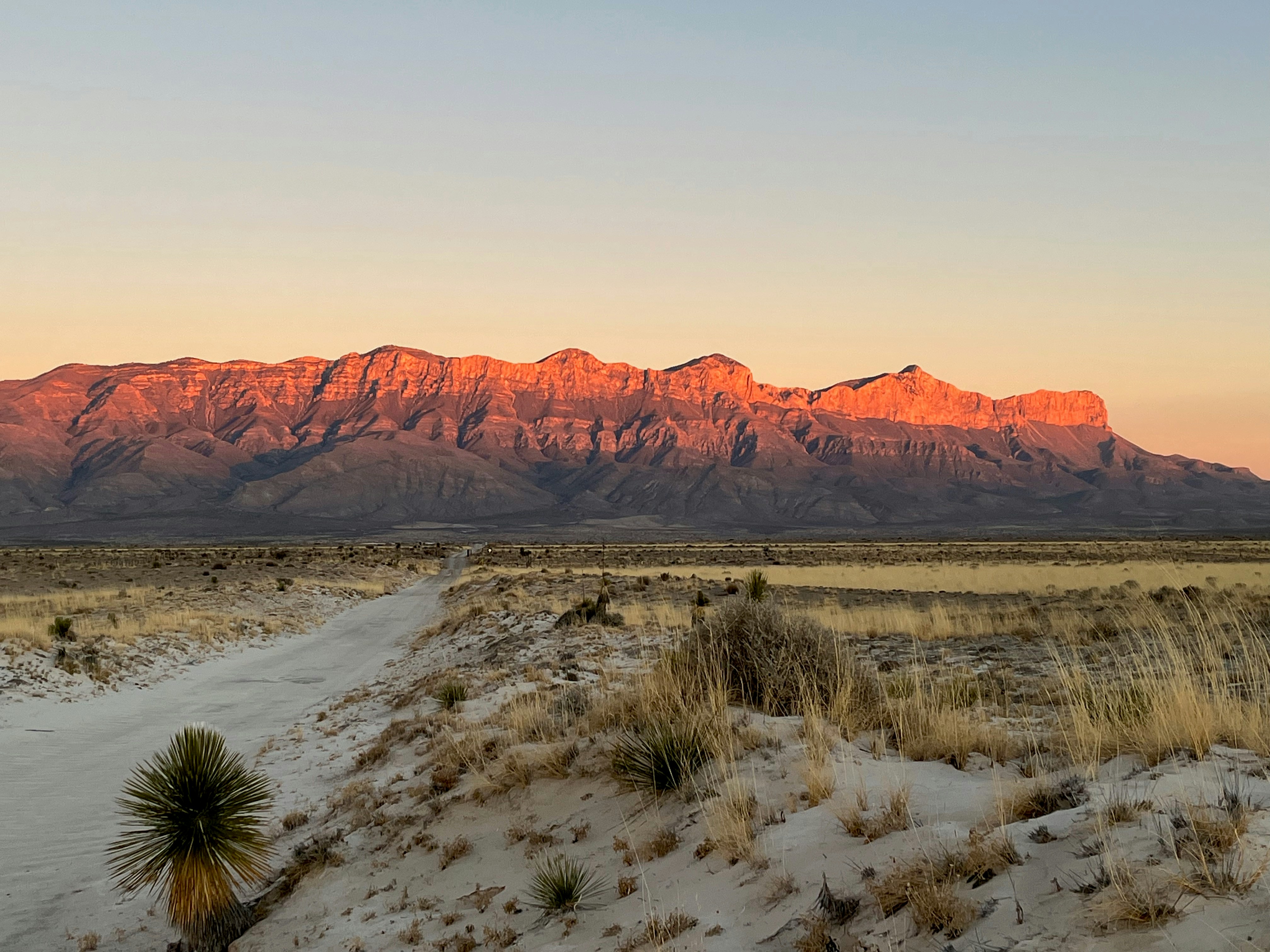 Un camino de tierra frente a una cordillera