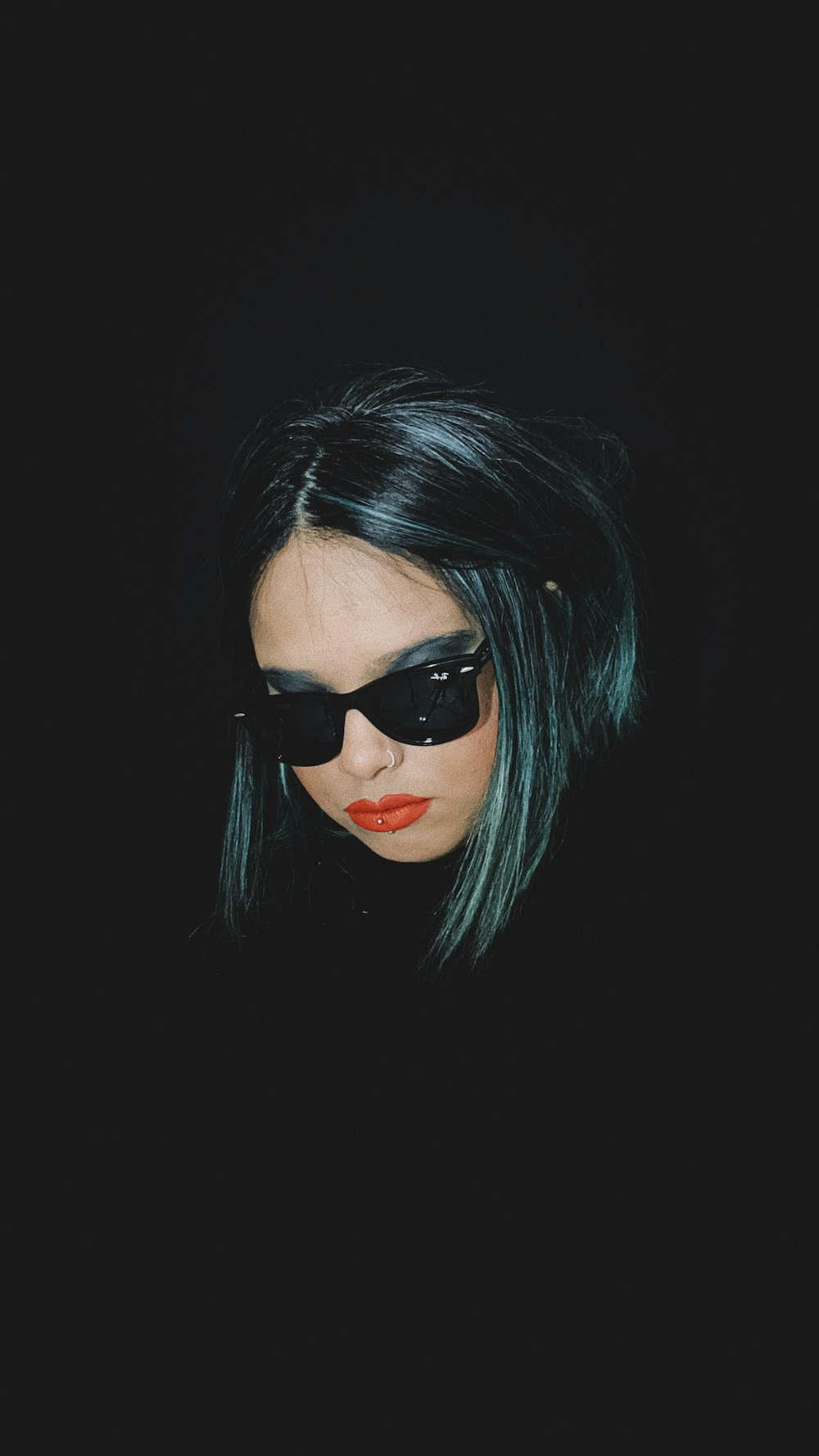 a woman with black sunglasses and green hair