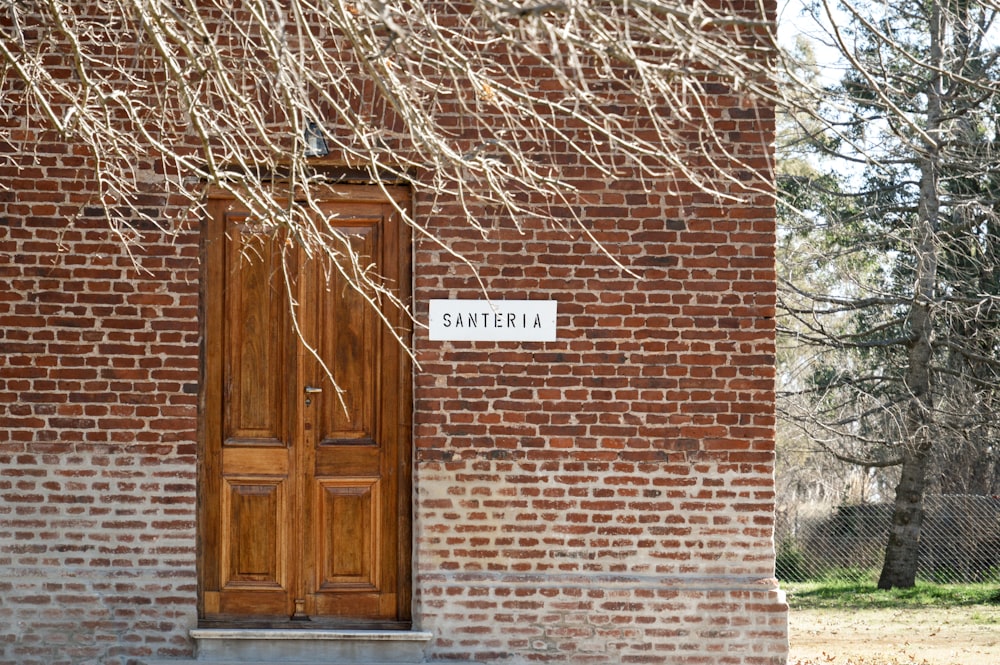 a brick building with a wooden door and a sign on it