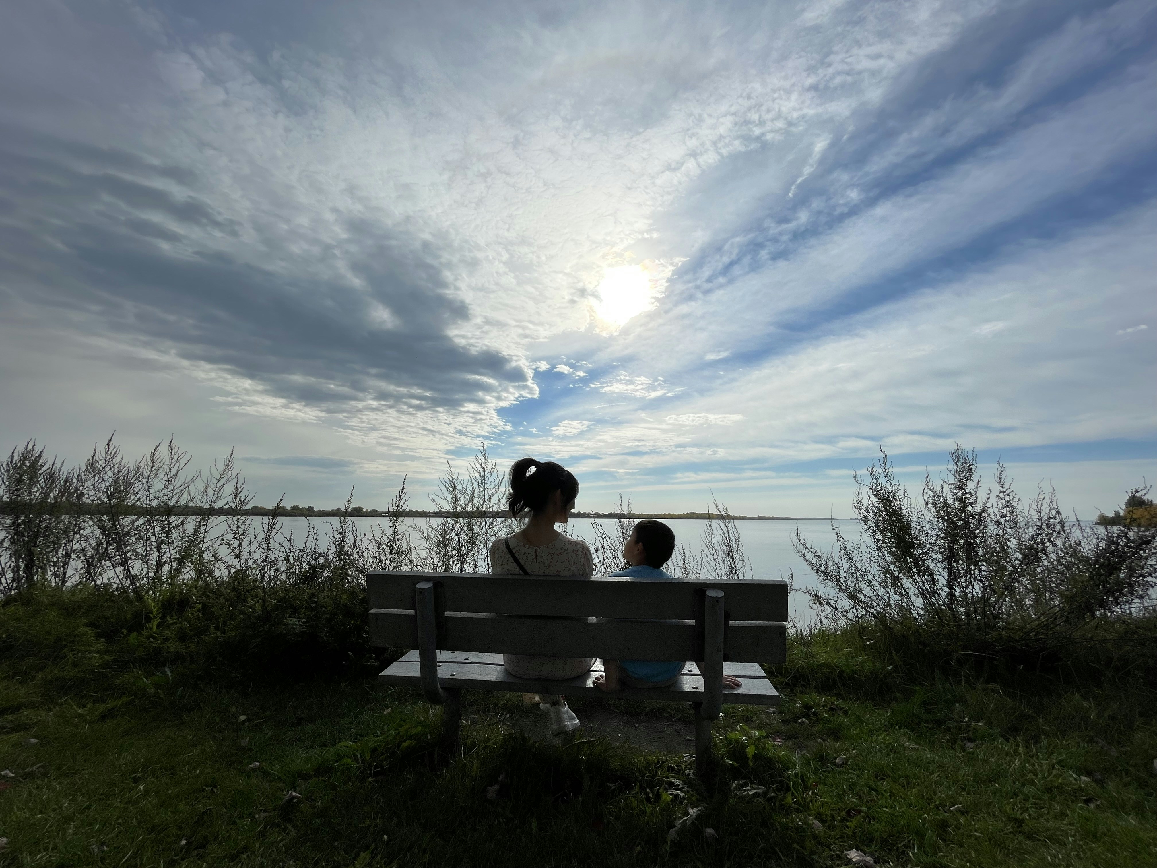 a woman and a child sitting on a bench