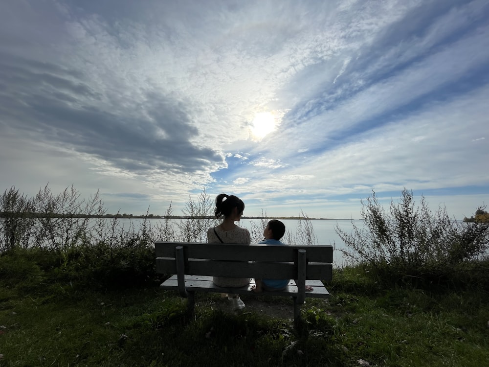 a woman and a child sitting on a bench