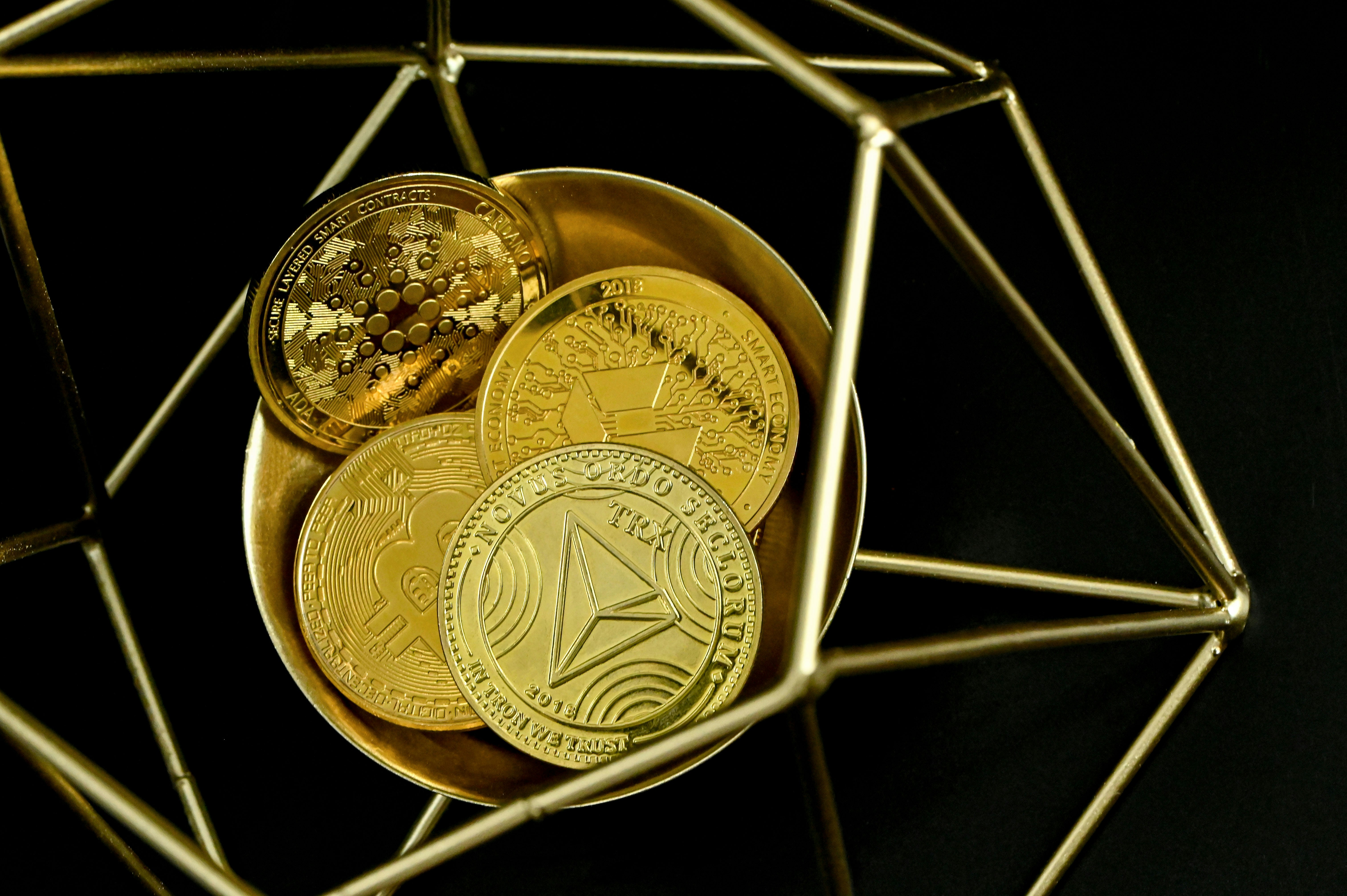 A group of cryptocurrency coins in a golden cage