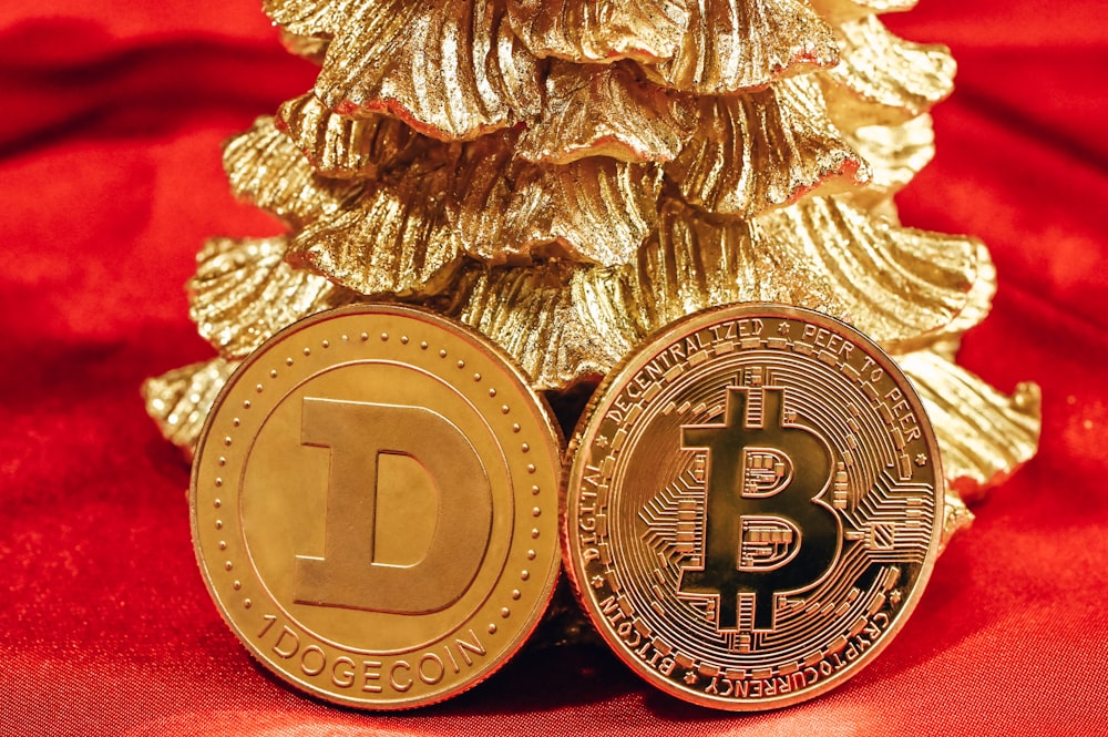 a gold bit coin next to a gold christmas tree